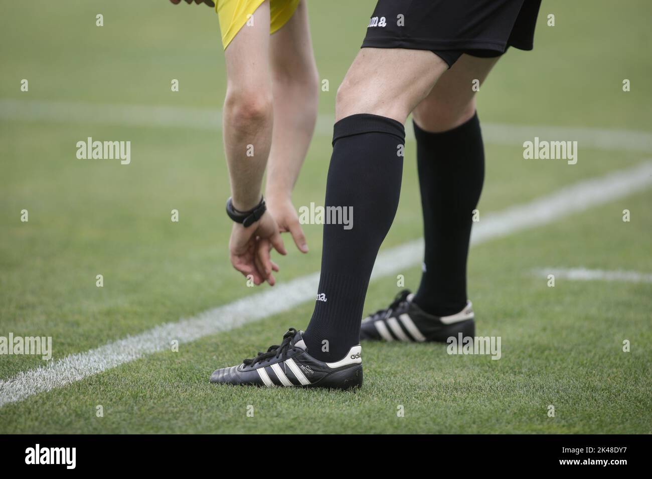 Giurgiu, Romania - June 29, 2020: Details with a football (soccer) referee stretching before a game. Stock Photo