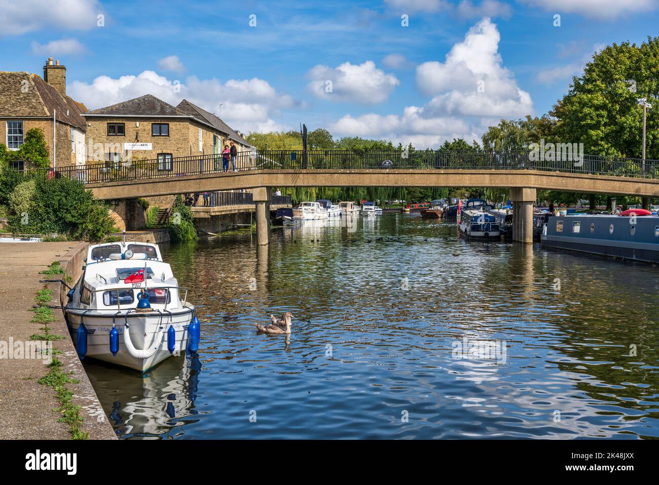 Boats moored on River Great Ouse with the Babylon Bridge in the background in Ely, Cambridgeshire, England, UK Stock Photo