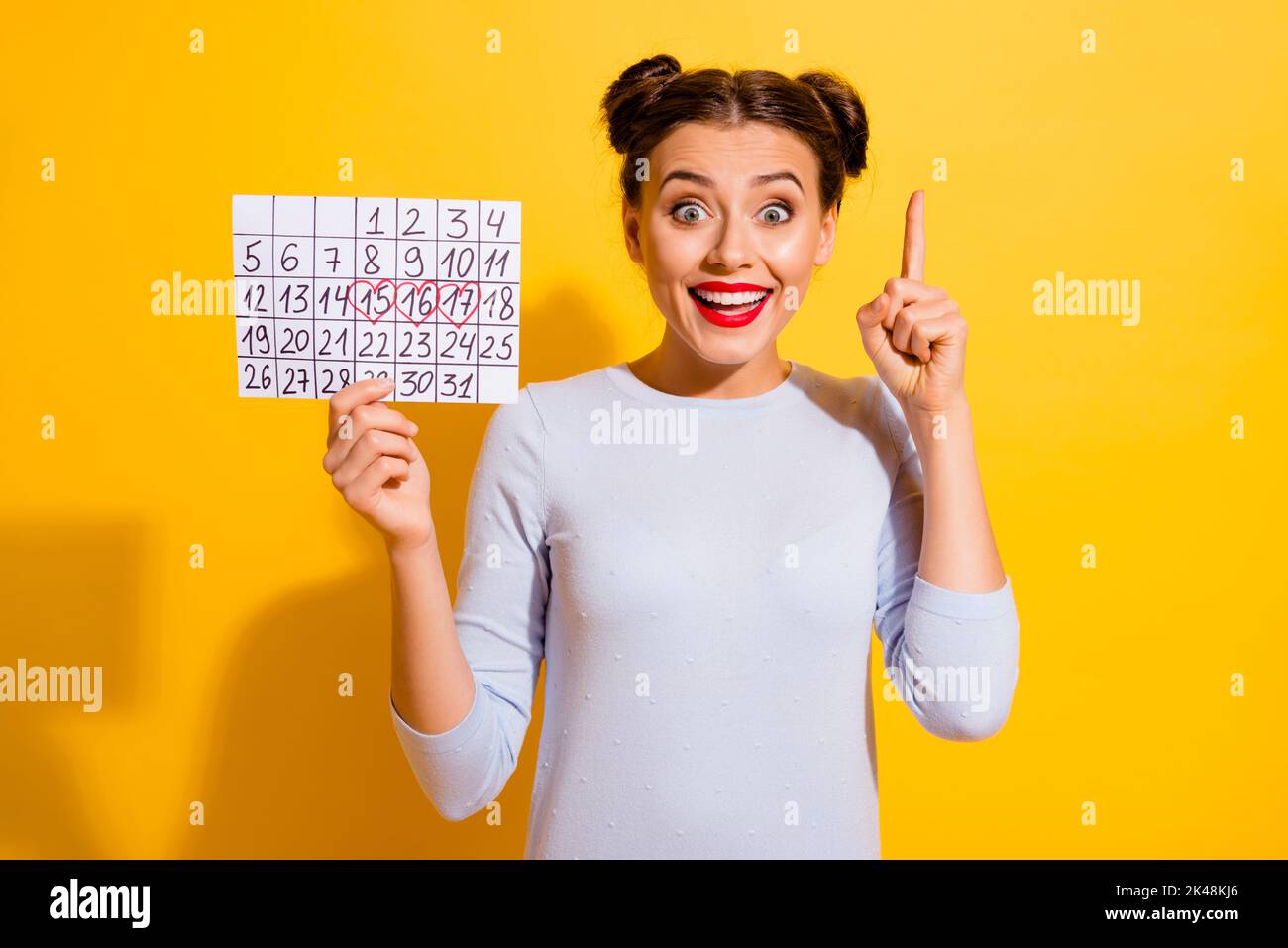 Photo of adorable excited girl dressed white shirt pointing finger holding planner isolated yellow color background Stock Photo