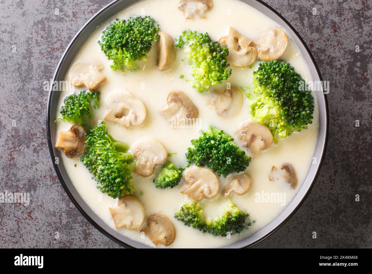 Tasty Mushroom Cheese Broccoli Soup close-up in the bowl on the table. Horizontal top view from above Stock Photo