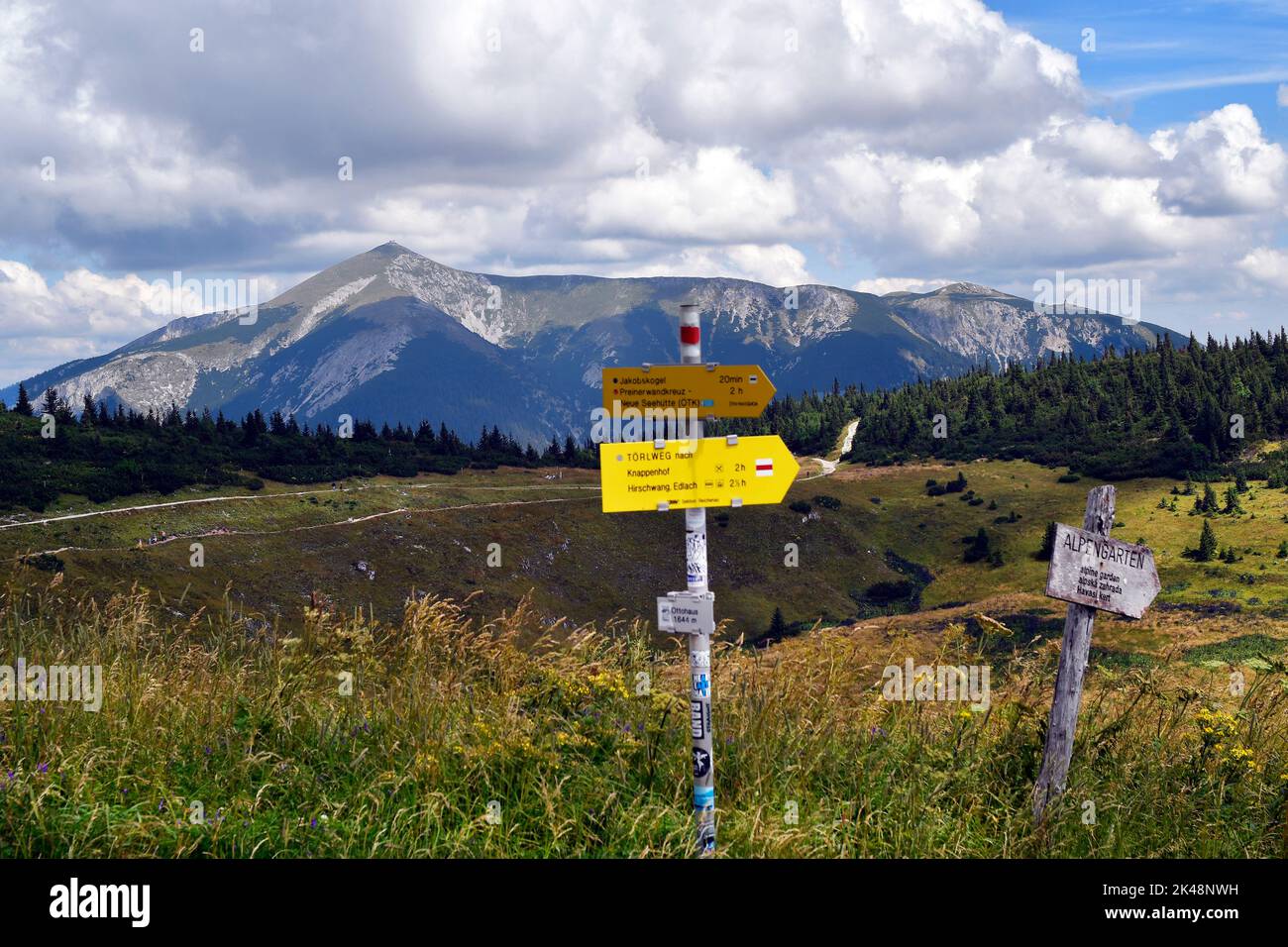 Austria, Rax mountain in Lower Austria, signposts with times to various destinations and Schneeberg mountain behind, part of the Vienna Alps Stock Photo