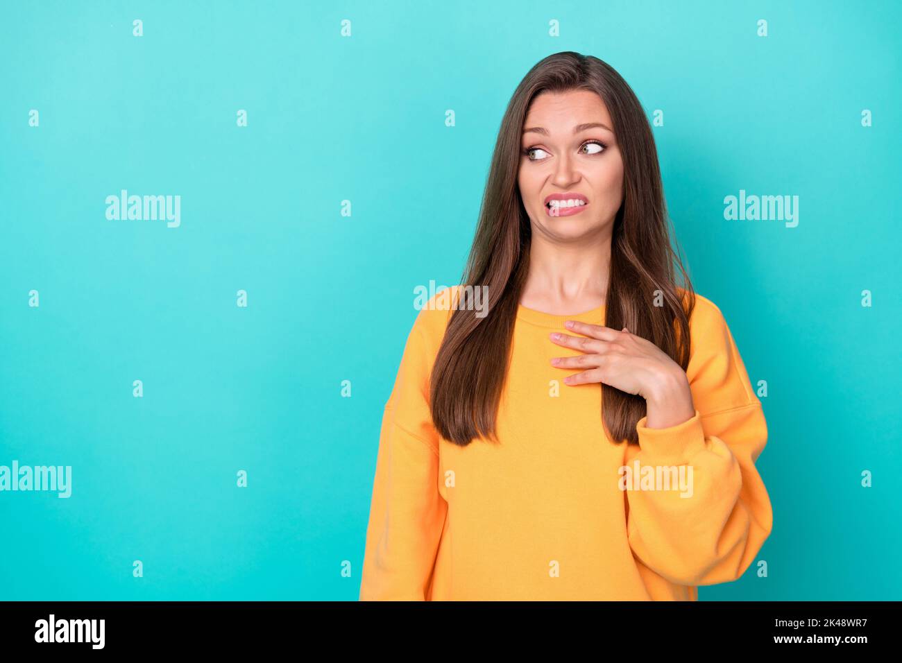 Photo of young attractive pretty nice woman wear yellow sweater touch chest funny grimace unhappy look empty space dissatisfied isolated on cyan color Stock Photo