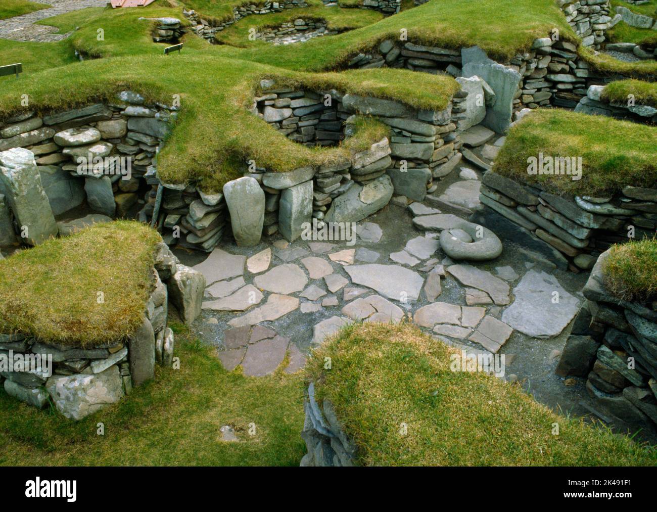 View S over Bronze Age House III at Jarlshof prehistoric settlement, Sumburgh, Shetland, Scotland, UK: an oval house with a clover-leaf internal plan Stock Photo