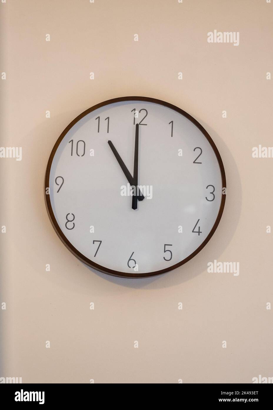 Eleven oclock 11am 11pm on traditional analogue clock on wall Stock