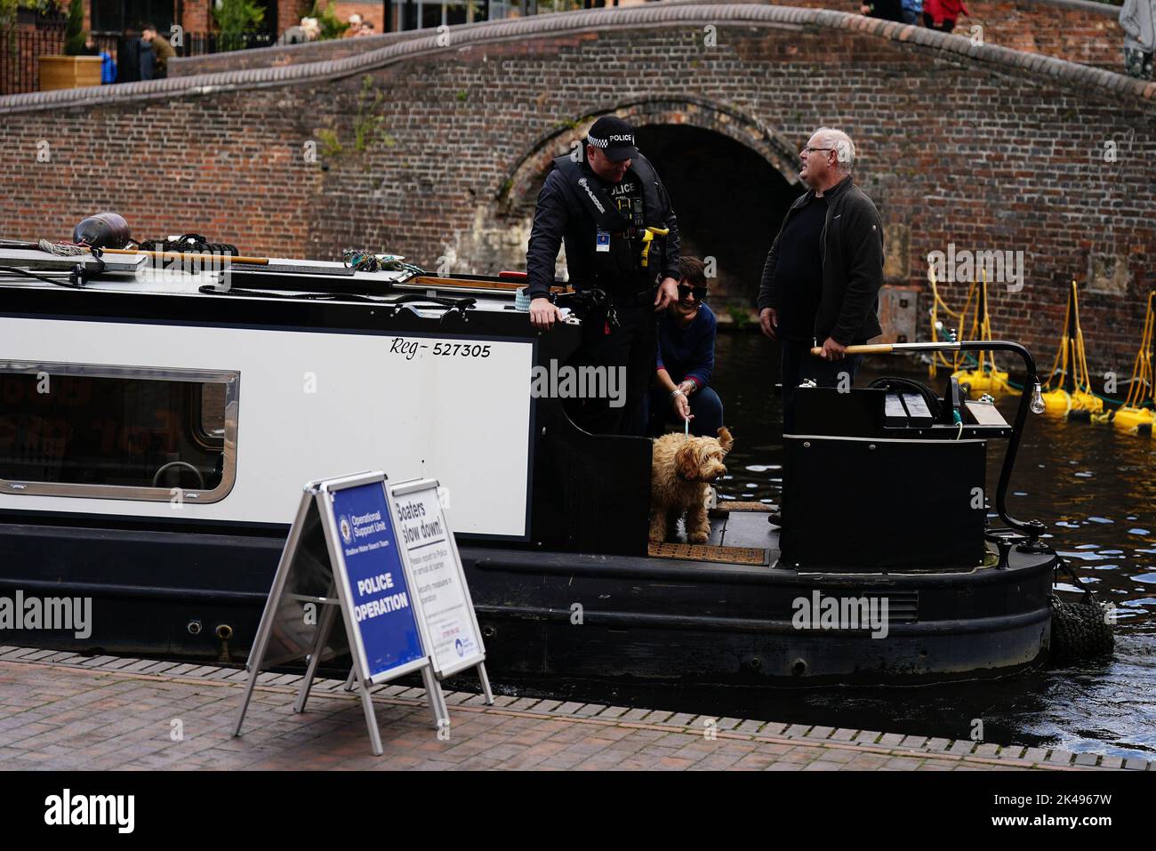 A police officer aboard a narrow boat on the canal in Birmingham ahead of the Conservative Party annual conference at the International Convention Centre. Picture date: Saturday October 1, 2022. Stock Photo