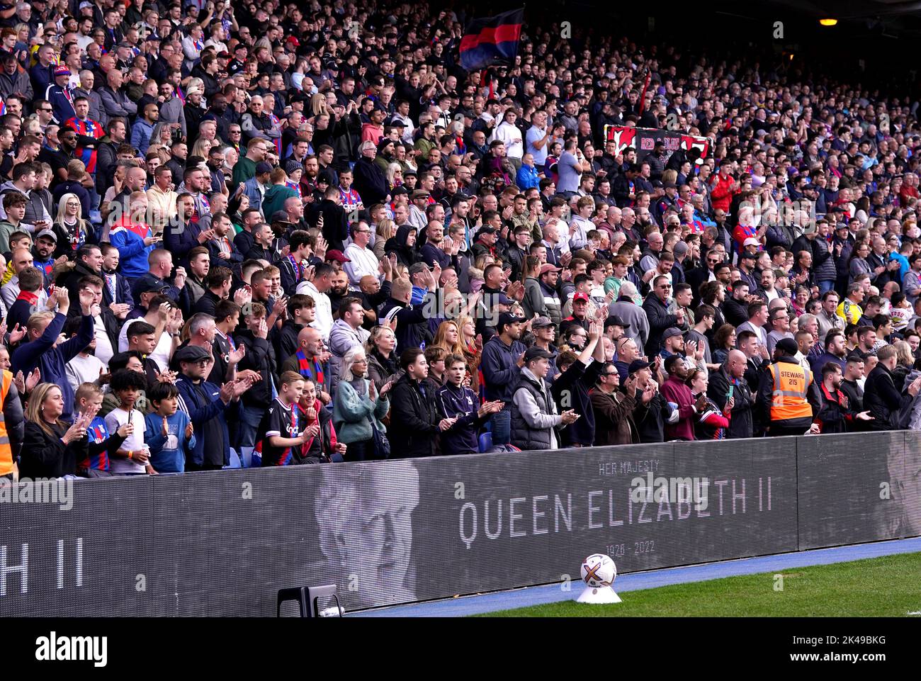 Crystal Palace fans sing the national anthem as a tribute to Queen Elizabeth II is displayed on the electronic advertising boards ahead of the Premier League match at Selhurst Park, London. Picture date: Saturday October 1, 2022. Stock Photo