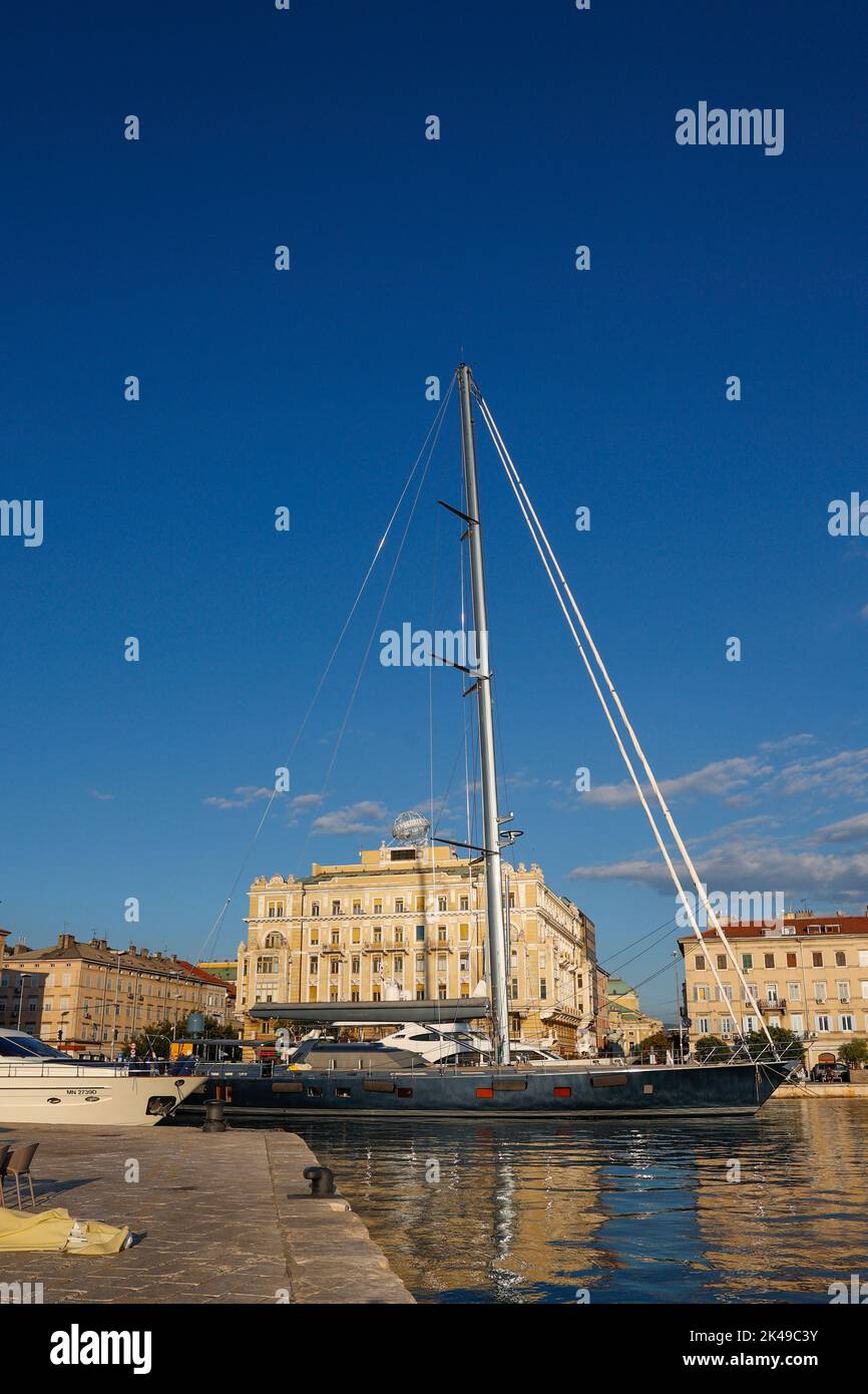 View of yacht anchored in the harbour with Palazzo Bacich,  today the Transadria building in the background, Rijeka,Istria,Croatia Stock Photo