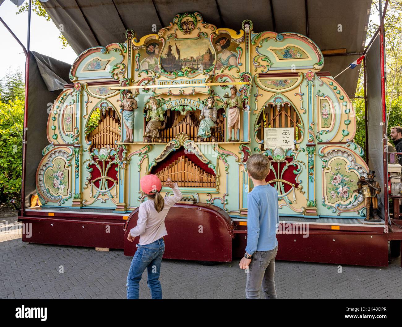 Children dancing in front of a Fairground organ at Keukenhof Gardens Stock Photo
