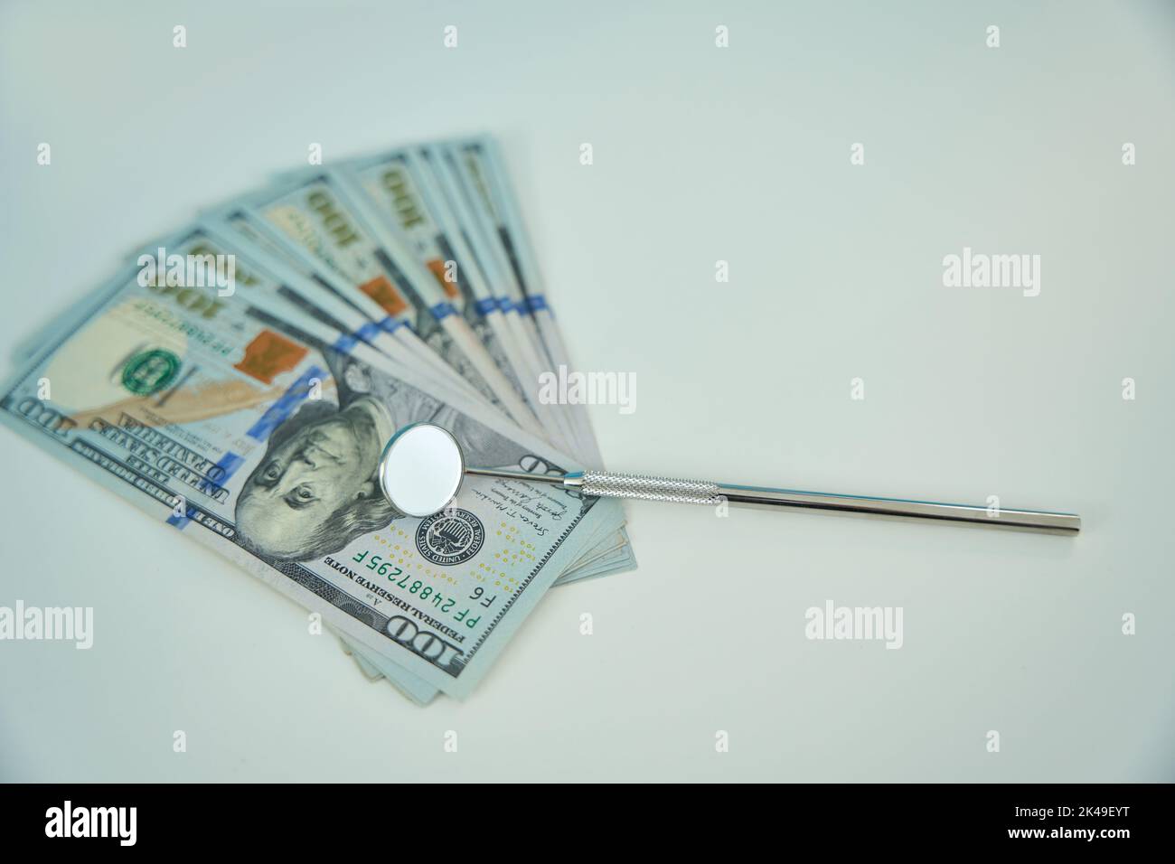 Dental mirror for oral cavity on lying on dollar bills Stock Photo Alamy