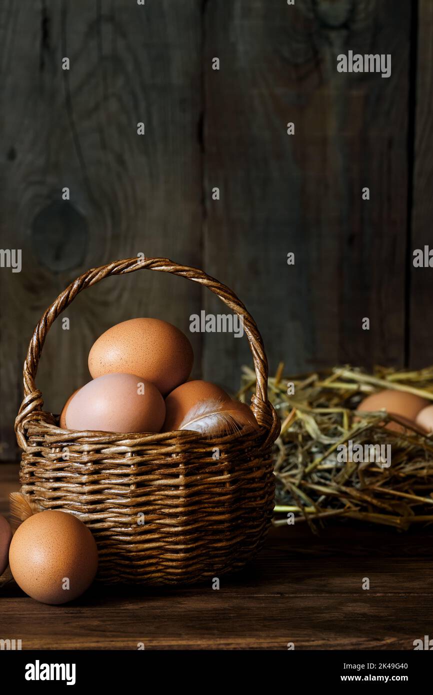 chicken eggs in wicker basket and in hay Stock Photo