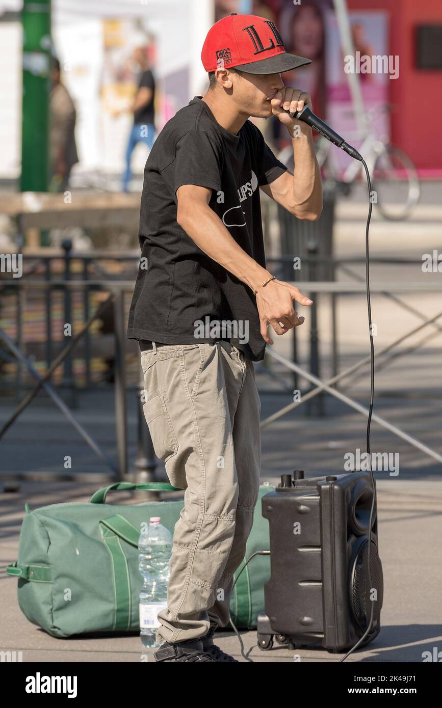 A boy beatbox performs in a street of the city center of Milan. The beatboxing is a form of