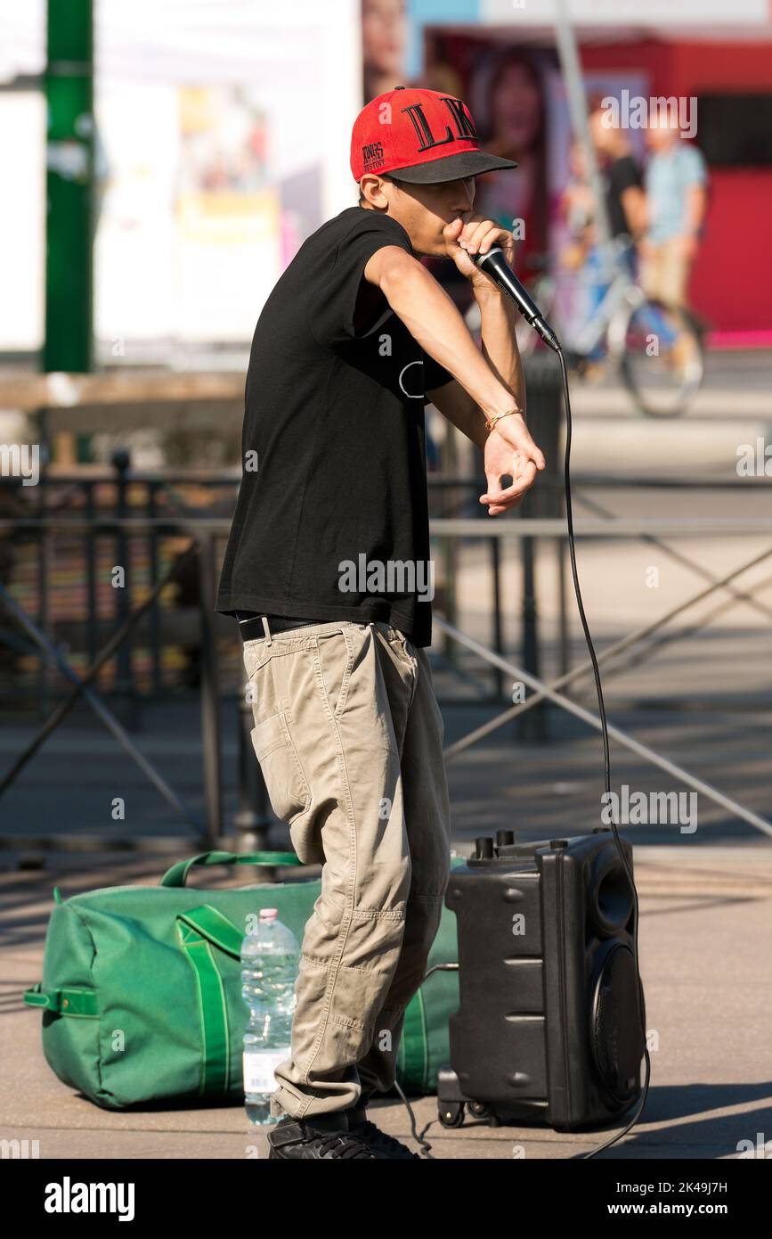A boy beatbox performs in a street of the city center of Milan. The beatboxing is a form of