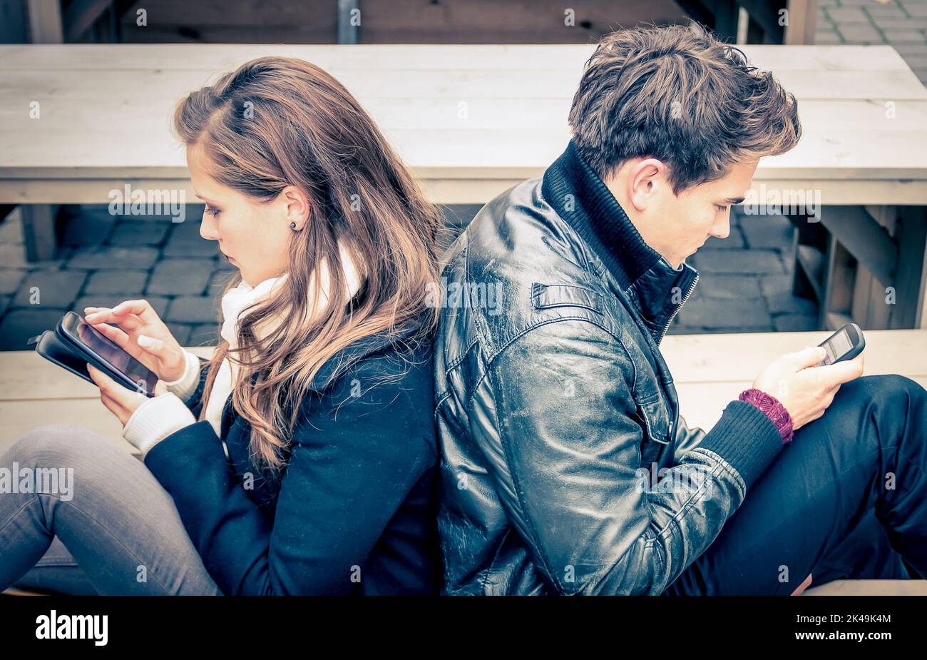 Couple in a modern common phase of mutual disinterest and sadness - Concept of apathy connected to the alienation fron new technologies - End of a lov Stock Photo