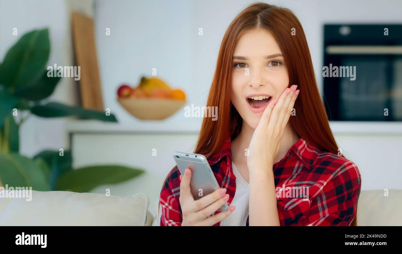 Amazed young user girl ginger student schoolgirl teenager use mobile