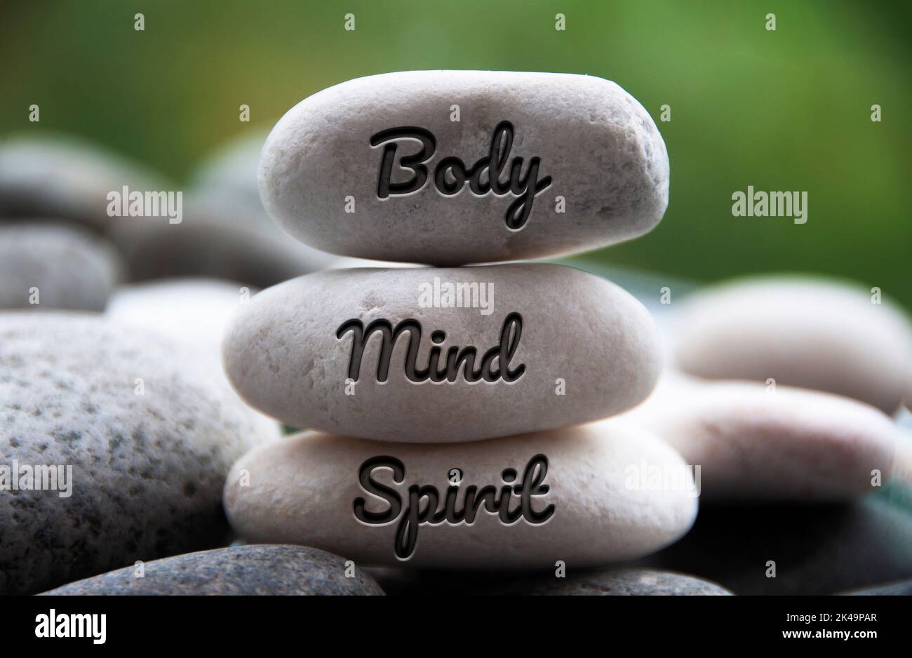 Body, Mind and Spirit words engraved on zen stones. Copy space and zen
