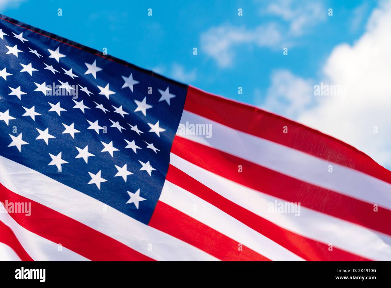 American flag waving in the wind against blue sky Stock Photo - Alamy