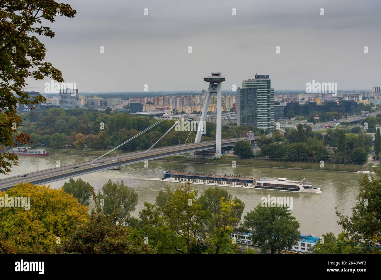 Bratislava, Slovakia - 25 September, 2022: a river cruise ship travels underneath the UFO Bridge on the Danube River in Bratislava Stock Photo