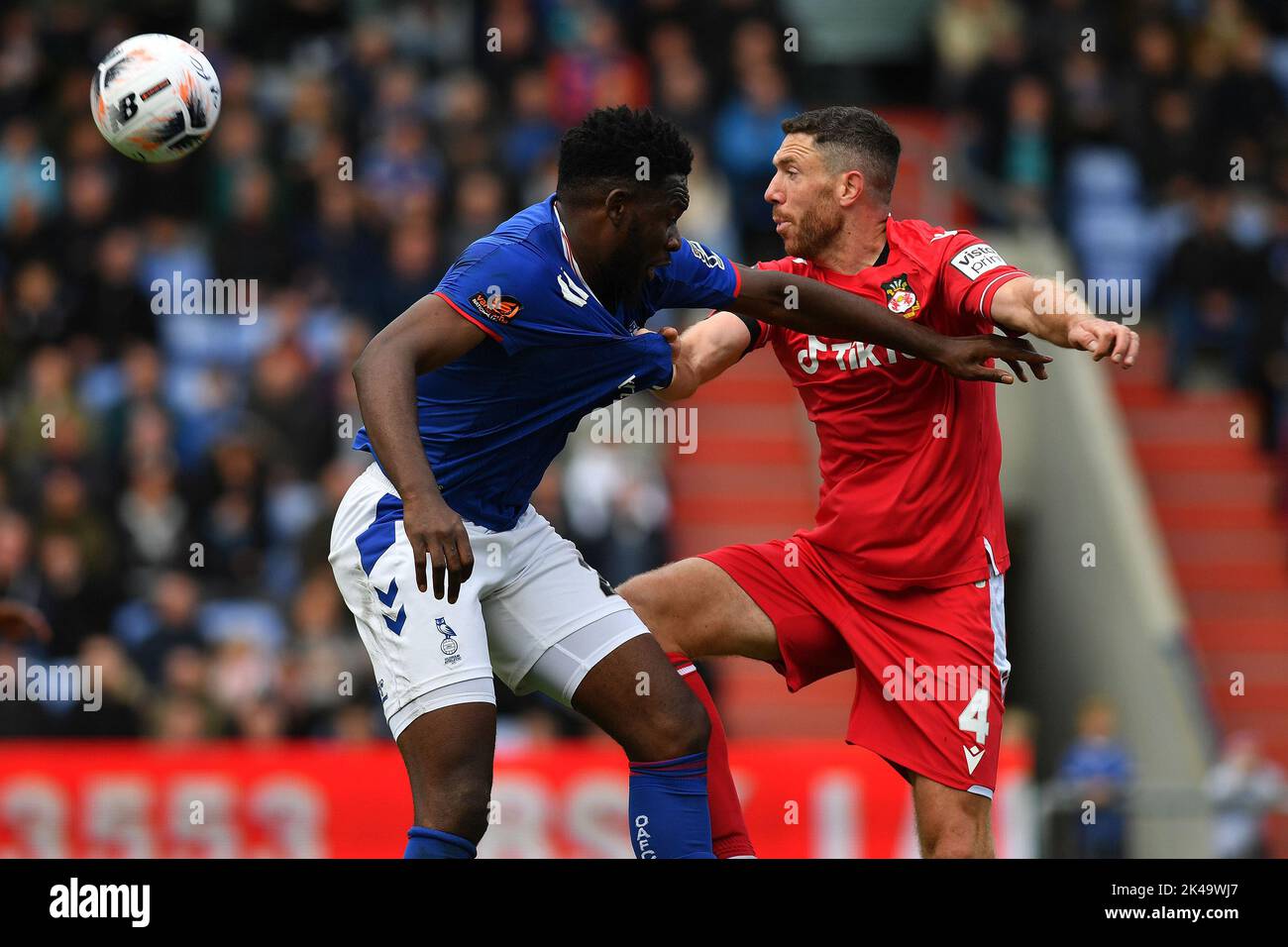 Oldham, UK. 1st October 2022during the Vanarama National League match between Oldham Athletic and Wrexham at Boundary Park, Oldham on Saturday 1st October 2022Mike Fondop-Talom of Oldham Athletic tussles with Ben Tozer of Wrexham Football Club during the Vanarama National League match between Oldham Athletic and Wrexham at Boundary Park, Oldham on Saturday 1st October 2022. Credit: MI News & Sport /Alamy Live News Stock Photo