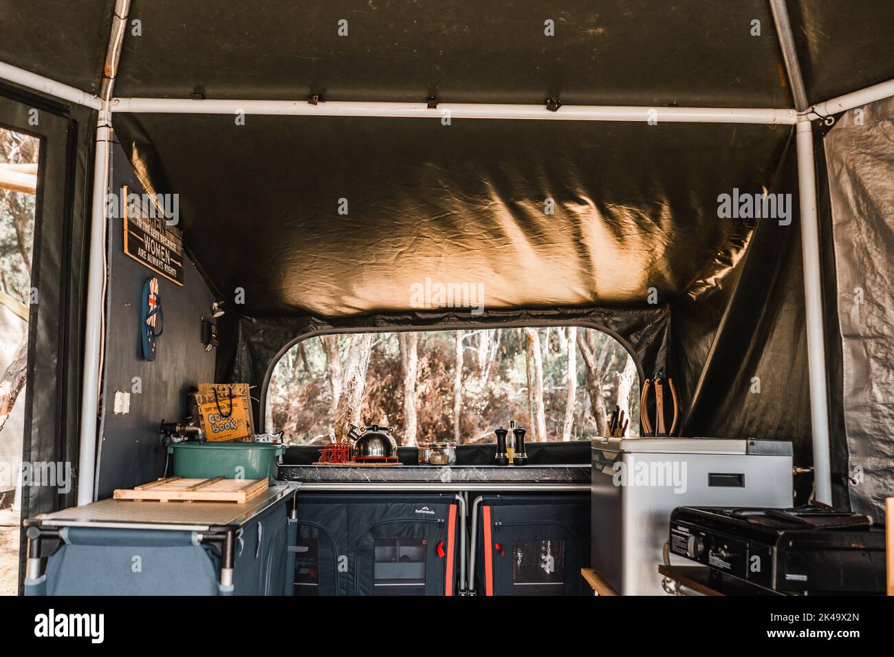 tent and kitchen in the middle of the forest with fridge stove table