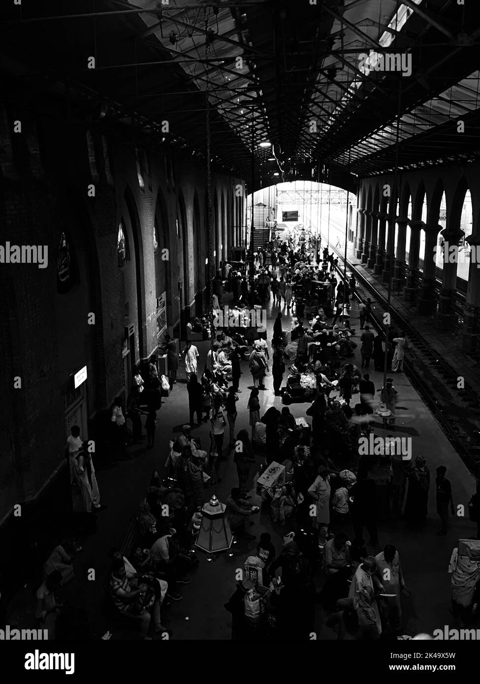 A grayscale shot of a crowded railway station Stock Photo