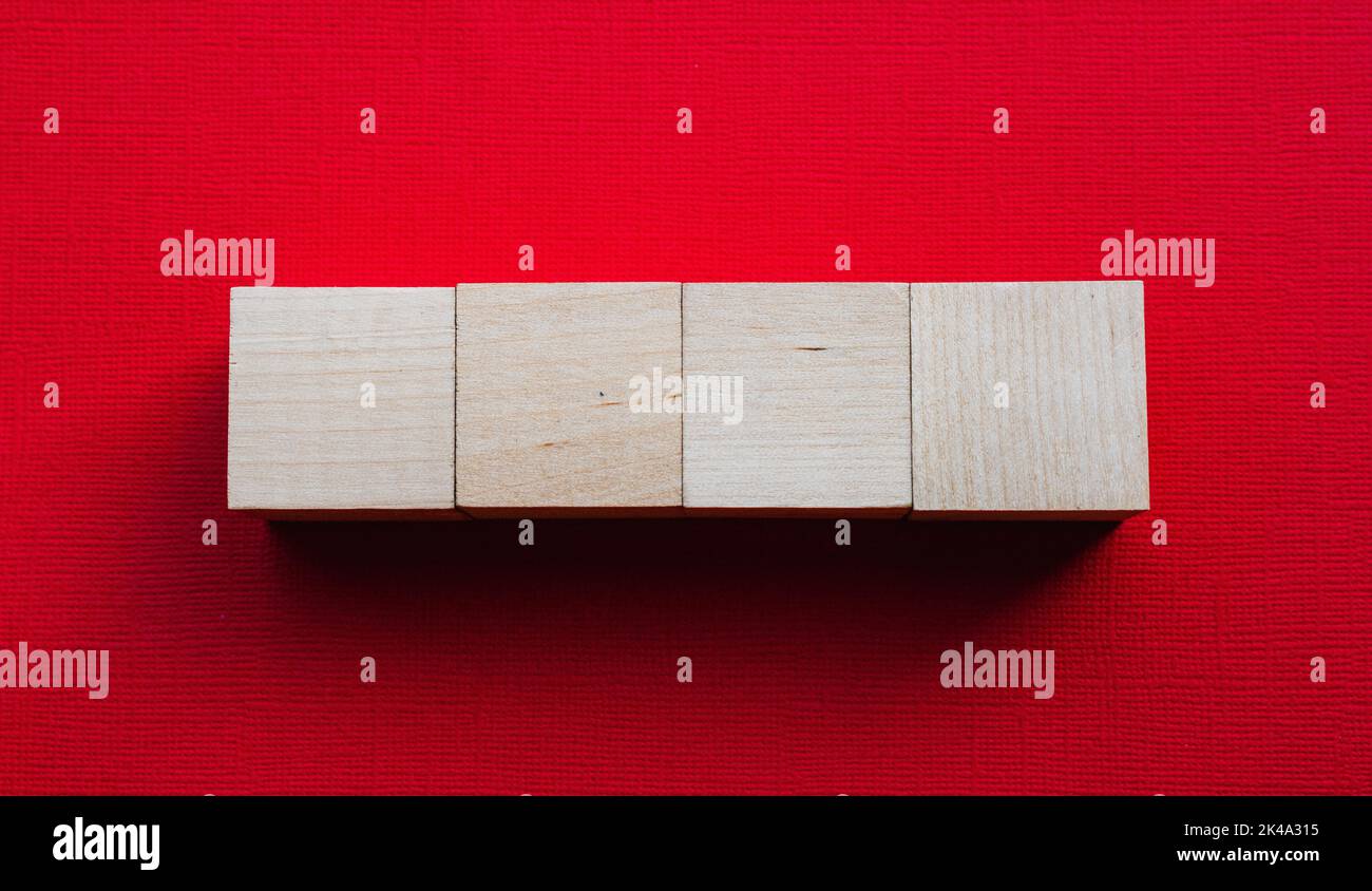 Four wooden cubes on a red background, mocap Stock Photo