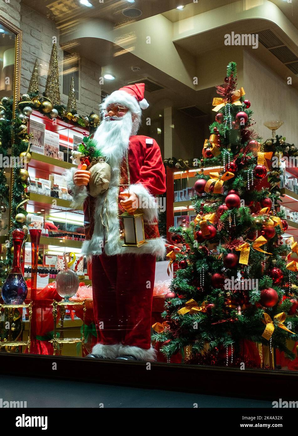 November 22, 2021, Moscow, Russia. Santa Claus and a Christmas tree in the window of a souvenir shop. Stock Photo