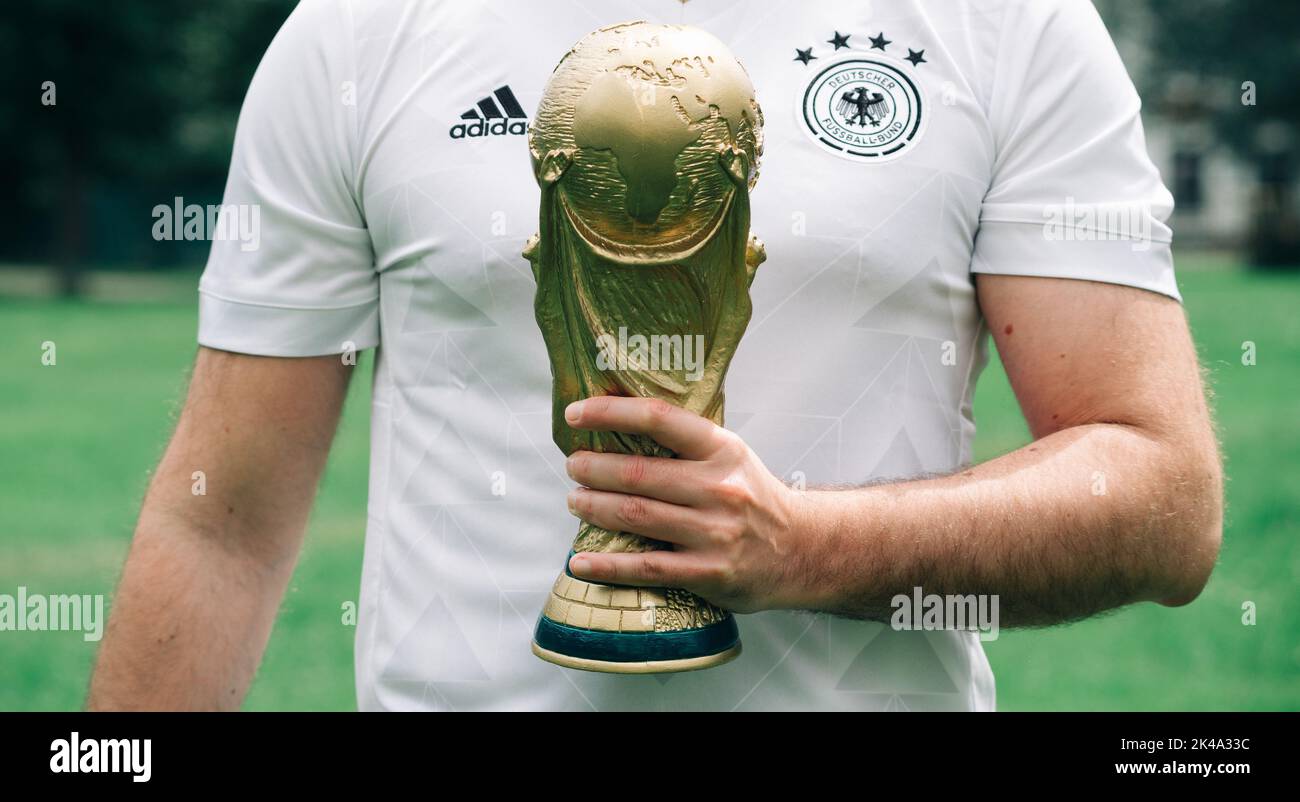 June 12, 2018, Doha, Qatar, A man in a German national team T-shirt holds the FIFA World Cup in his hands. Stock Photo
