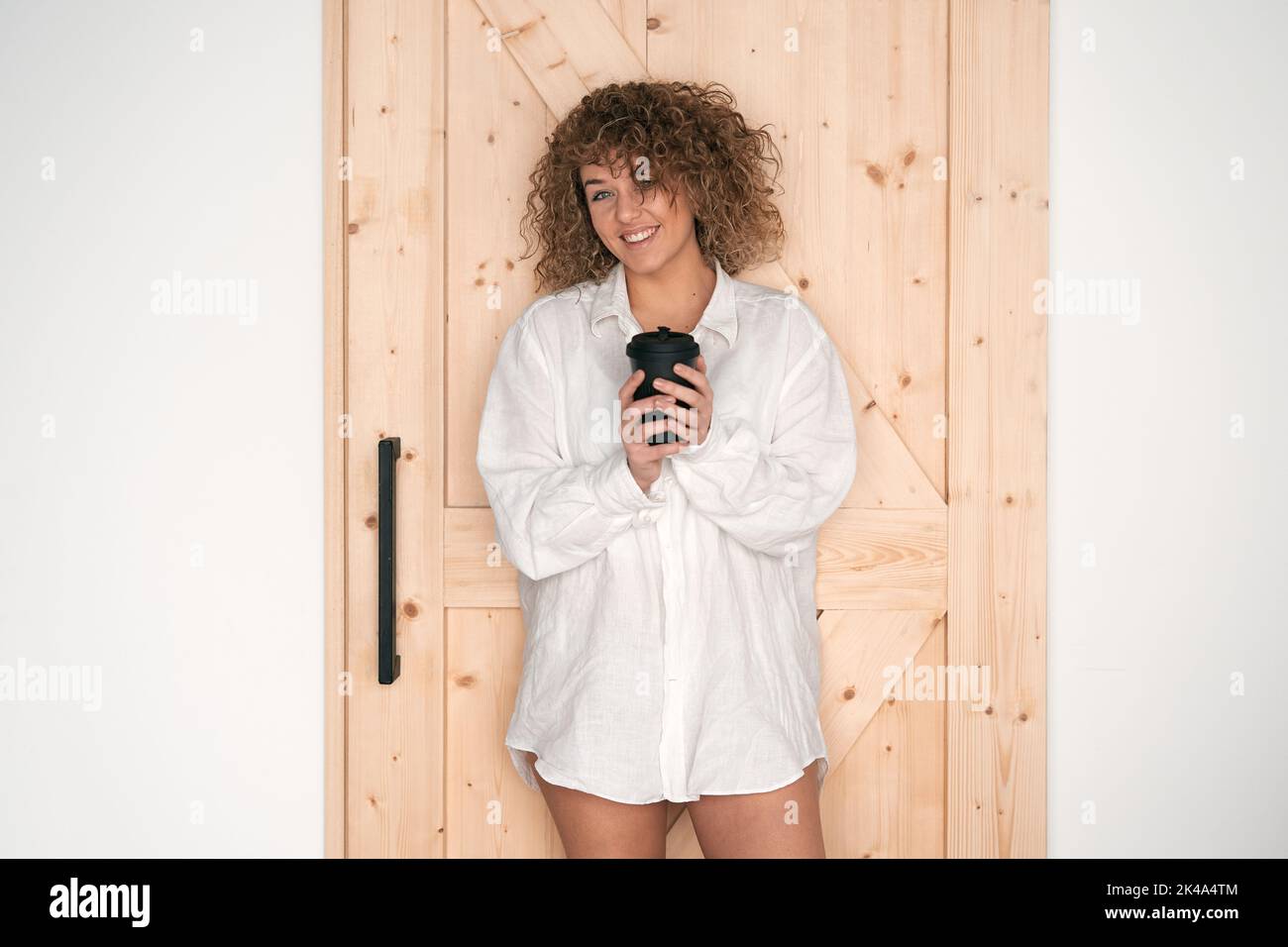 Charming curly lady in shirt with coffee Stock Photo