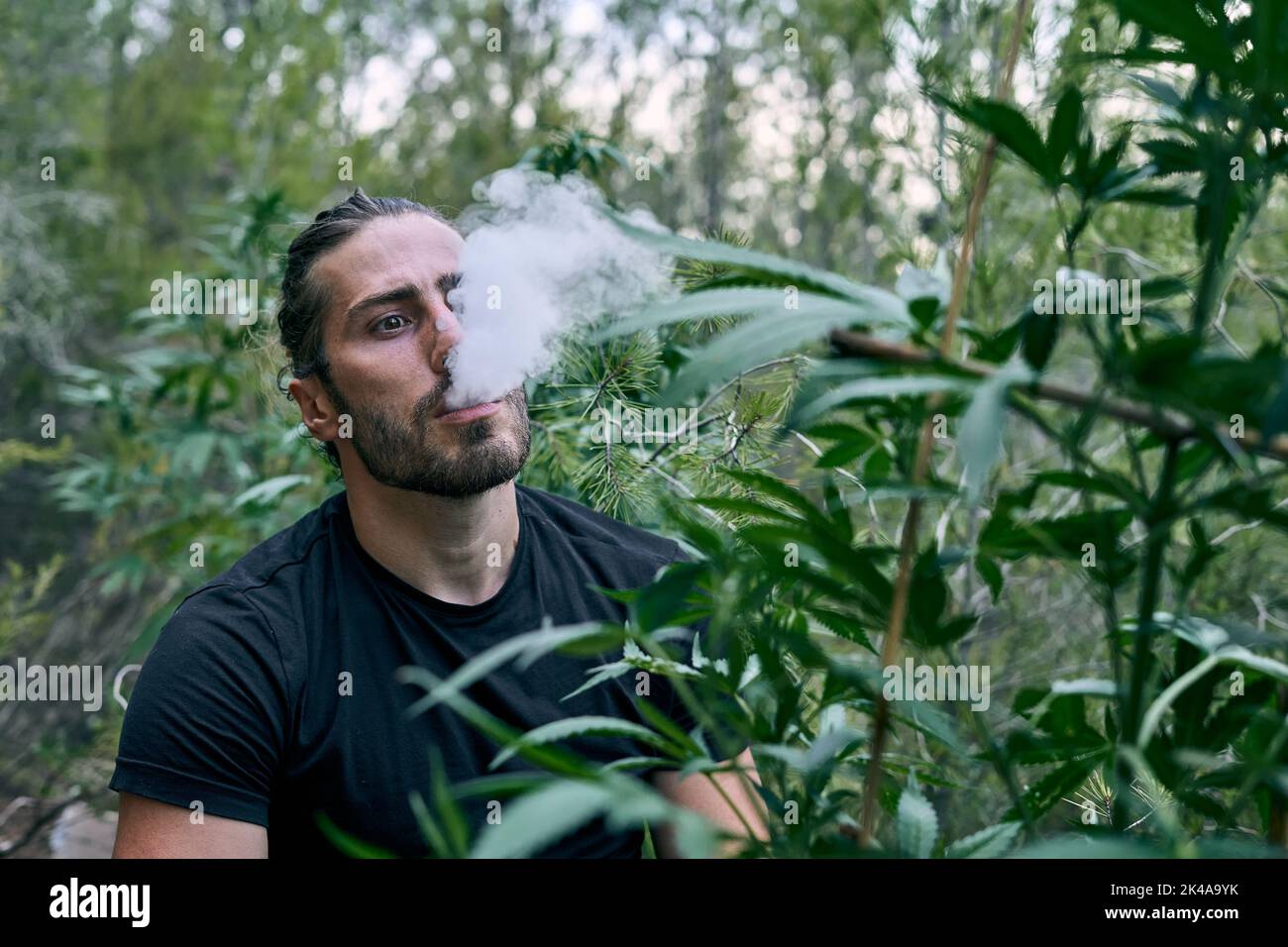 Caucasian man smoking with an electronic cigarette and spreading its