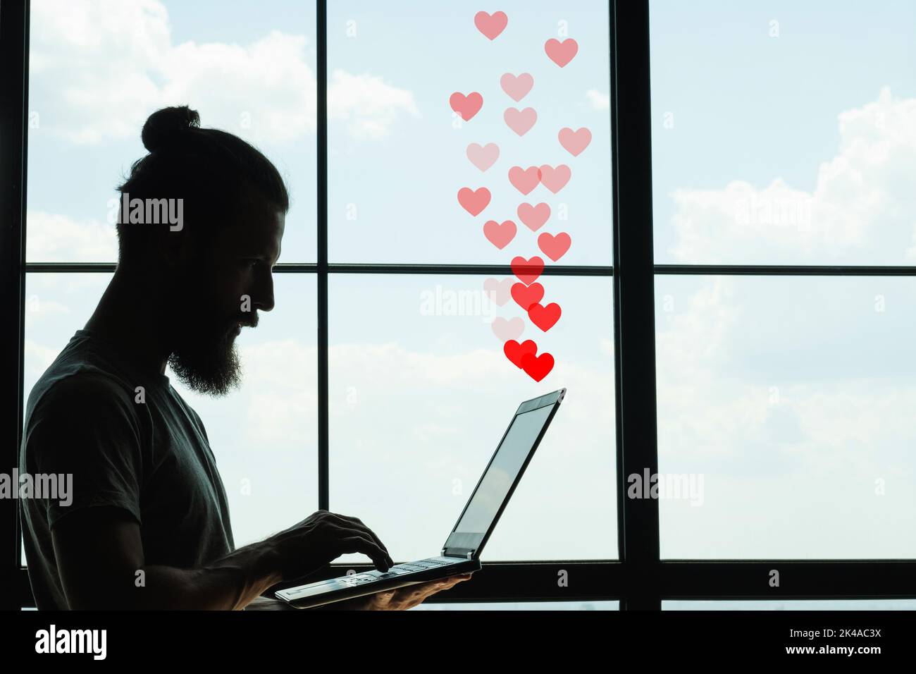 Travel blog. Positive feedback. Freelancer lifestyle. Social media. Side view silhouette of popular male hipster blogger writing content on laptop on Stock Photo