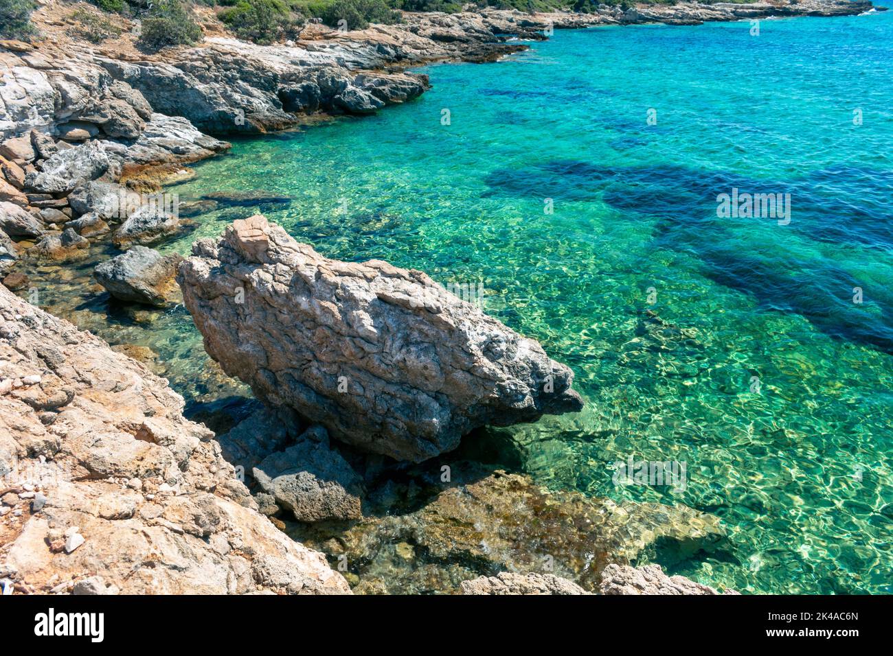 A rocky cliff near the clear blue sea water Stock Photo - Alamy