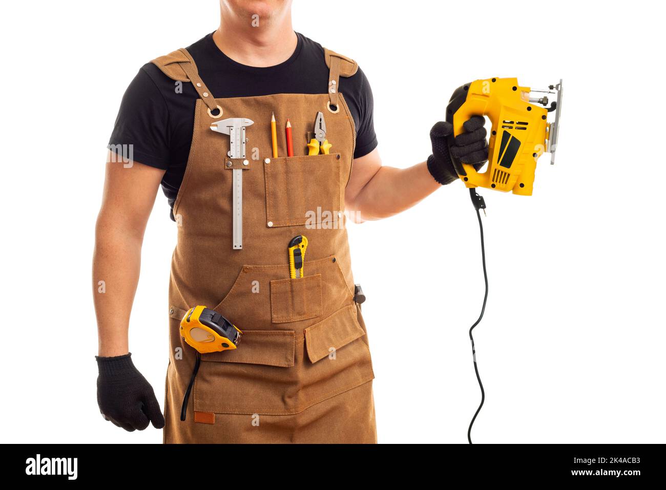 Carpenter in workers apron holding electric jig saw on white background Stock Photo