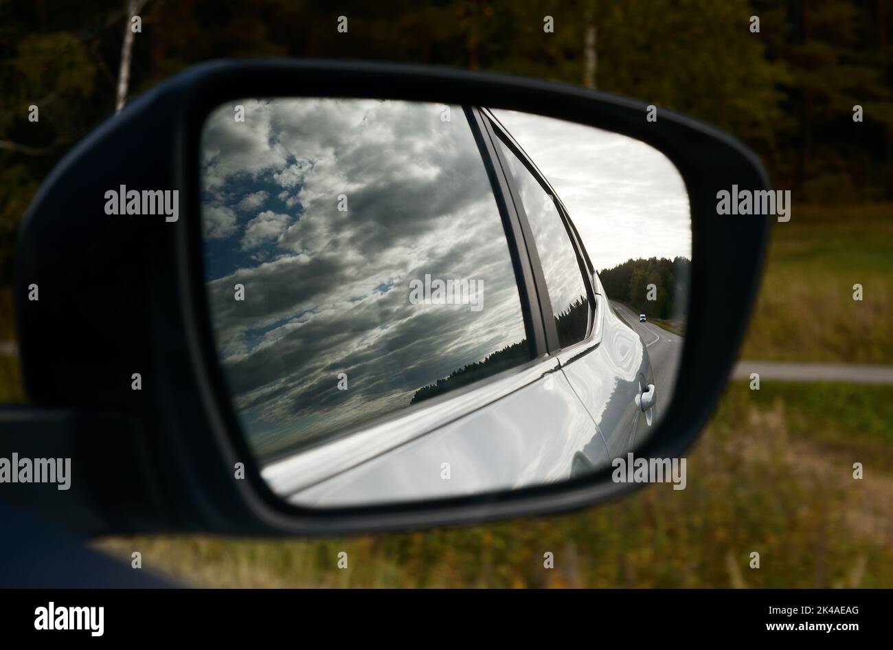 clouds and the road are reflected in the car's rearview mirror Stock Photo