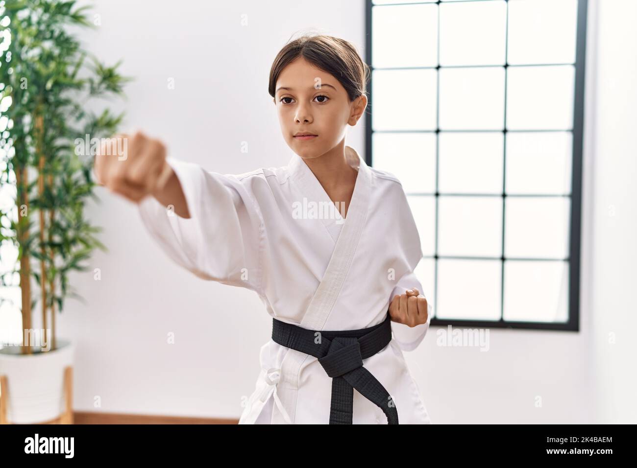 Young hispanic girl doing martial arts at training studio Stock Photo