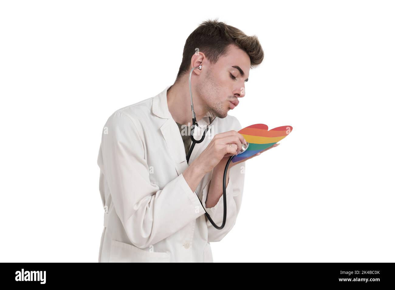 Young caucasian doctor taking care of lgbt flag heart, isolated. Stock Photo