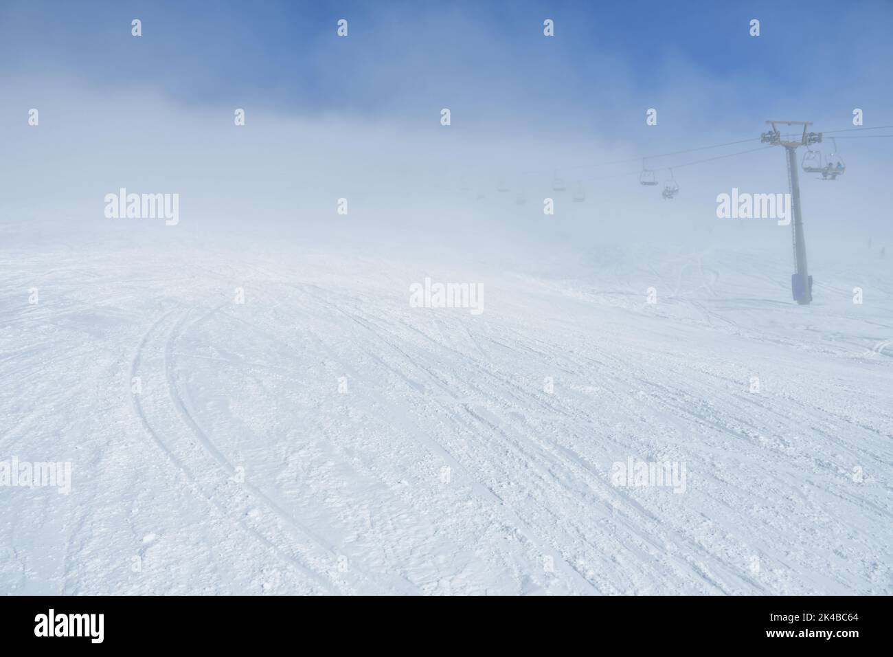 Ski resort Slope with limited visibility with nobody in the morning. Bad and changeable weather conditions Stock Photo