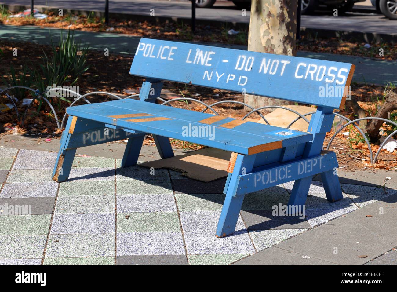 A NYPD police barricade upcycled for use as a park bench; a functional piece of furniture and art piece left at a park in Manhattan, New York Stock Photo