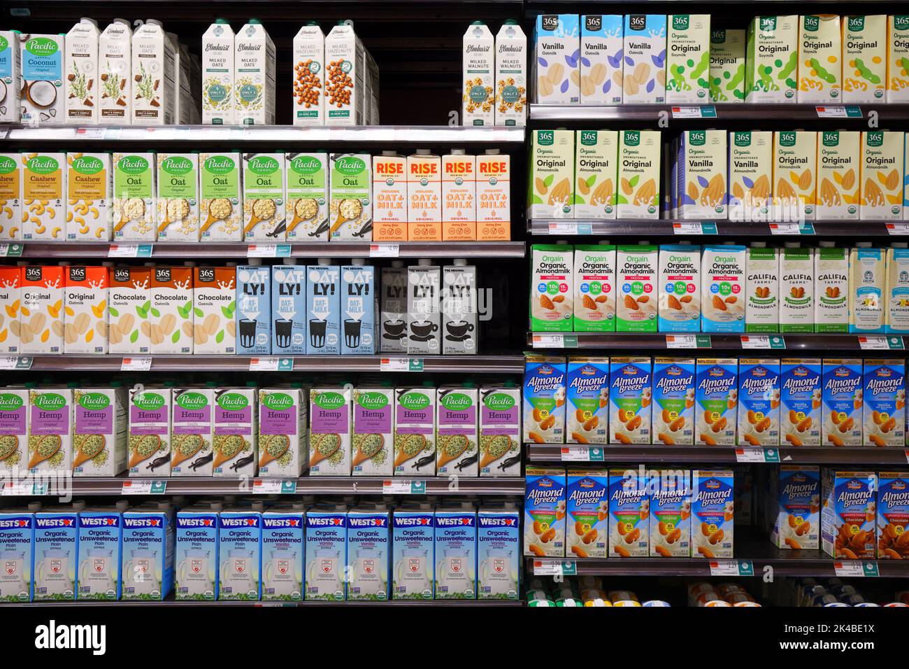 Tetra Pak cartons of non-dairy milk alternatives on a supermarket shelf. a choice paradox of different brands of soy, cashew, almond, hemp, oatmilk Stock Photo