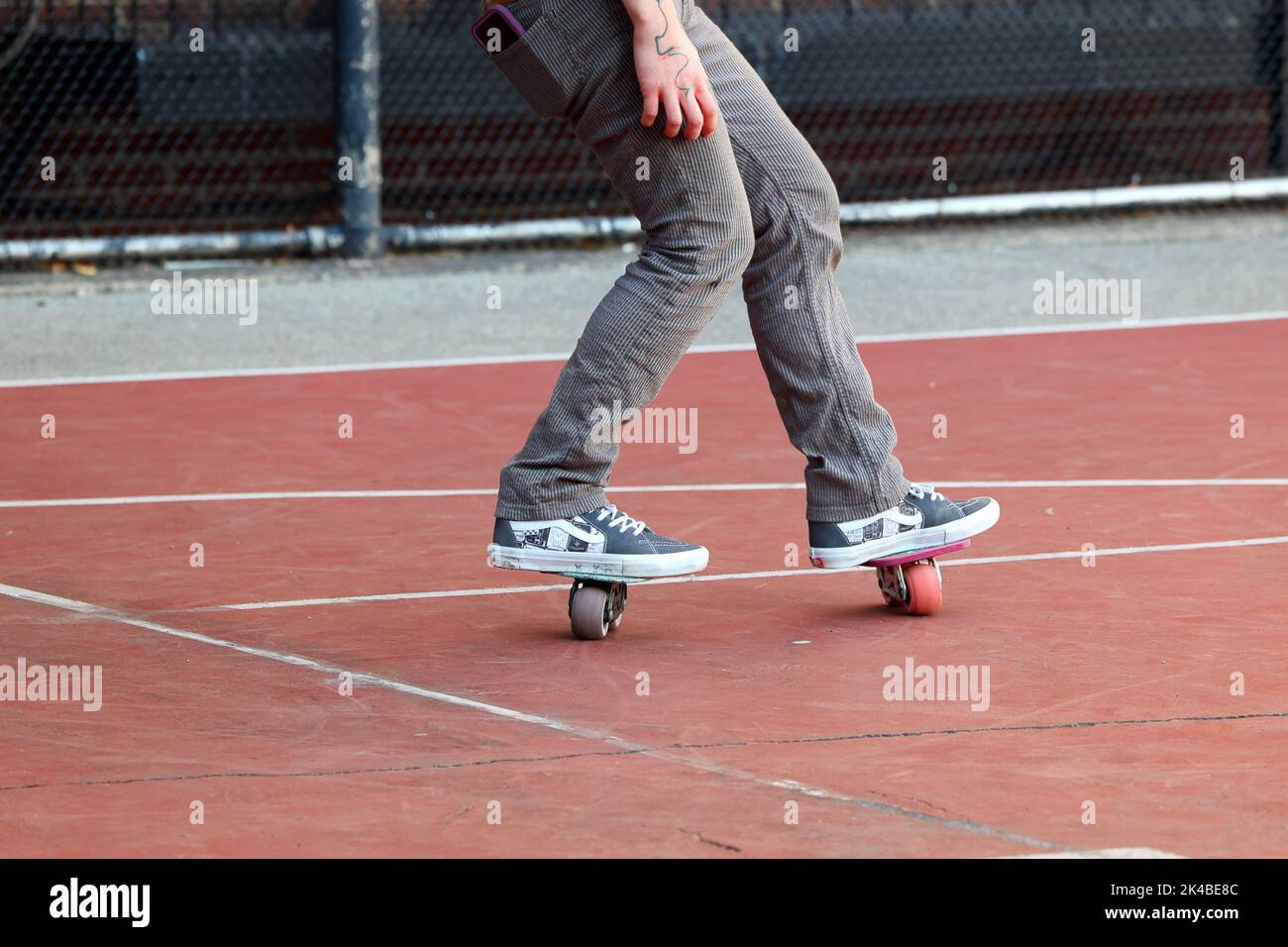 A person with freeline drift skates freeskating on an asphalt playground Stock Photo