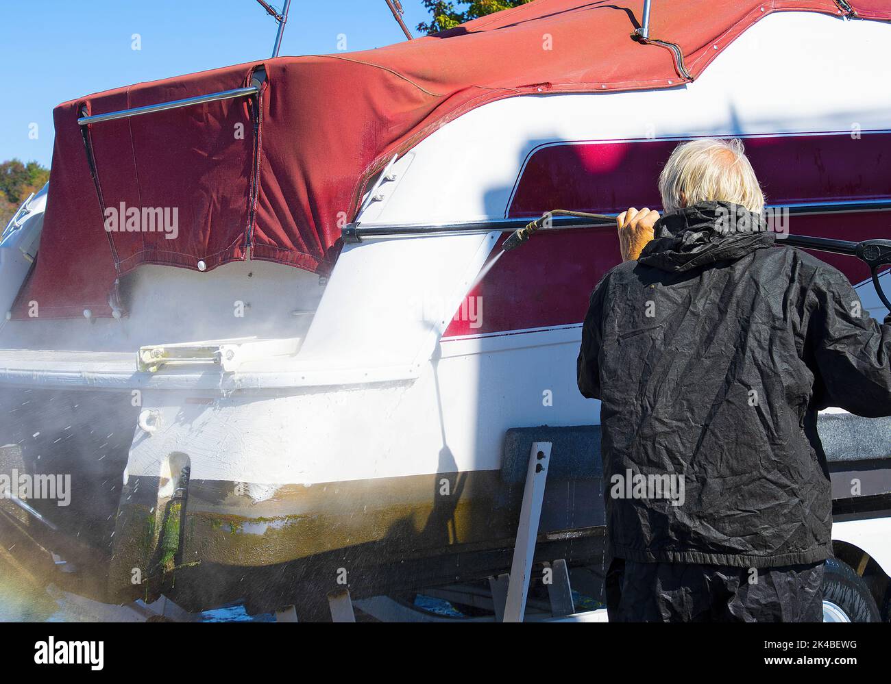 Caucasian man power washing boat hull Stock Photo Alamy