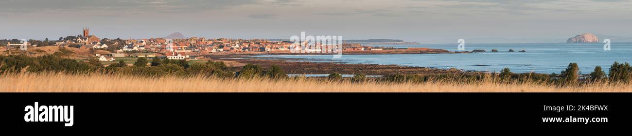 Wide panorama of Dunbar showing the whole town skyline, harbour and coastline including the Bass Rock and distant horizon during autumn sunrise. Stock Photo