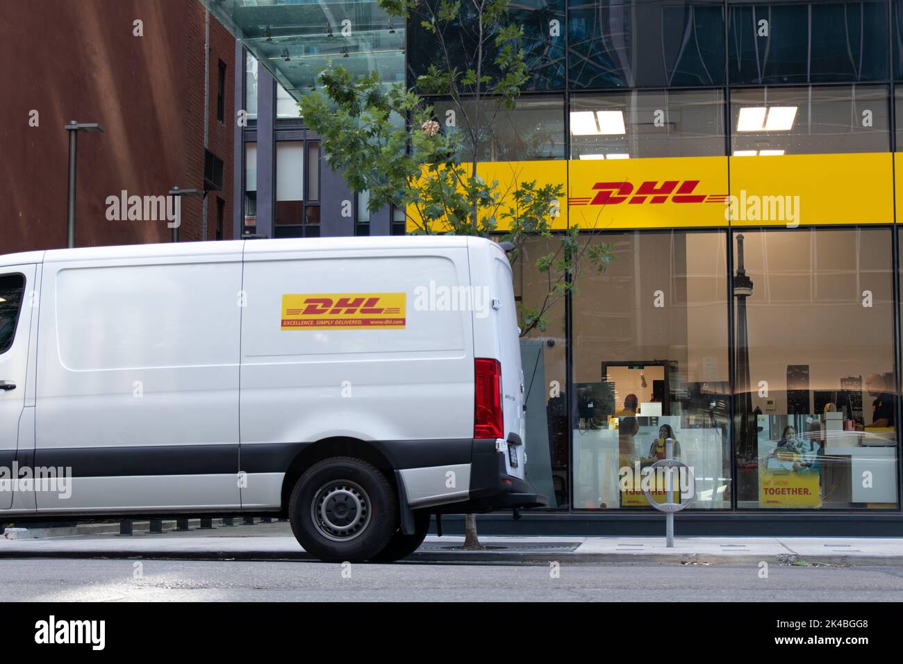 A DHL delivery van out front of a newly opened DHL office in downtown