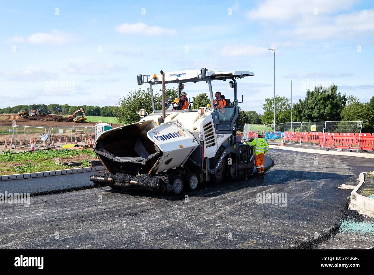 asphalt paver laying tarmac on a new road Stock Photo