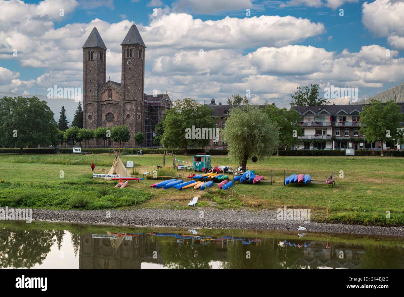 Ernst, Germany.  Saint Salvador Church in Background, canoe Rentals in foreground, Banks of the Moselle River. Stock Photo