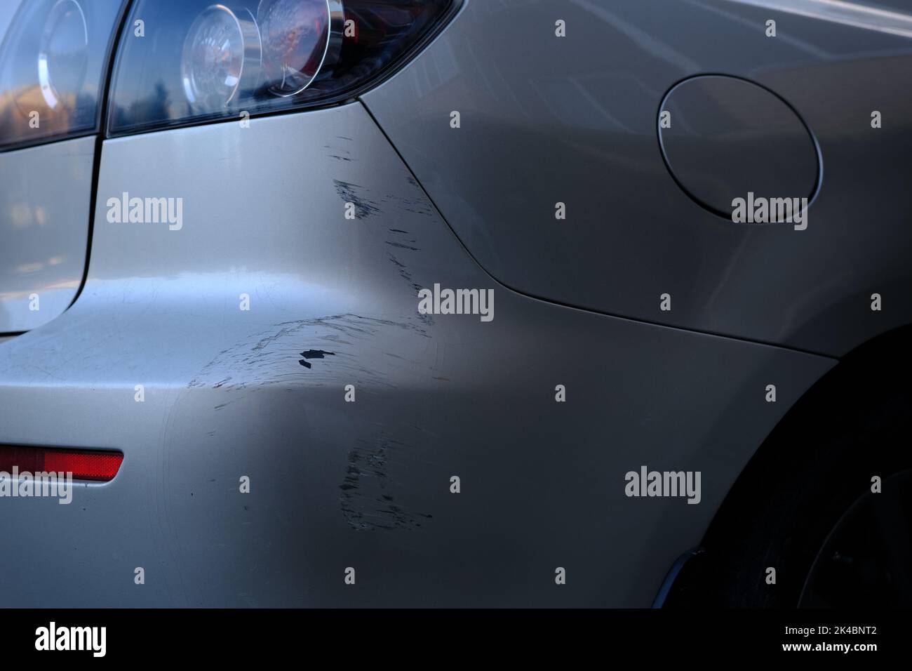 Scratched back bumper on the grey metallic car. Closeup image of