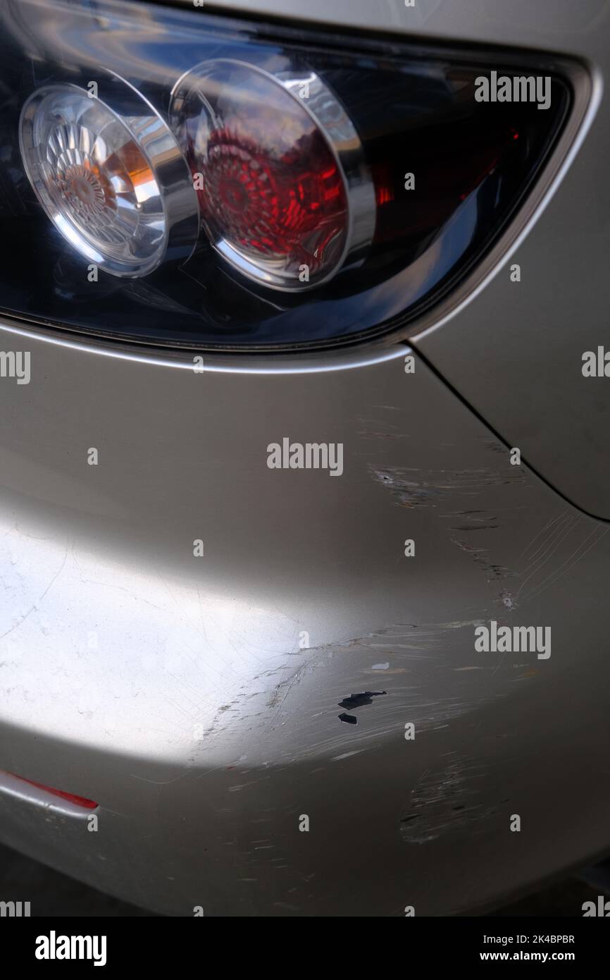 Scratched back bumper on the grey metallic car. Closeup image of