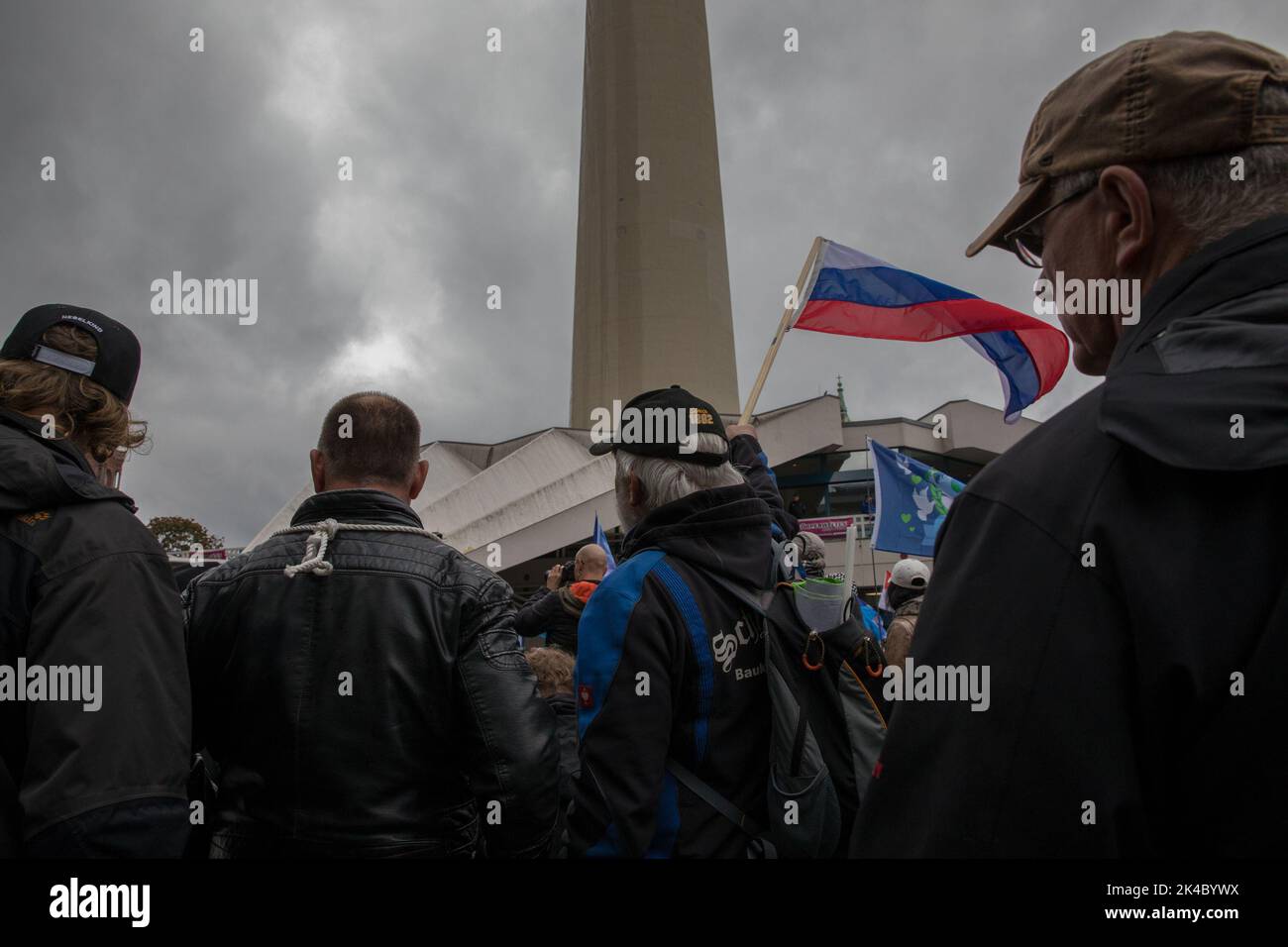 Berlin, Germany. 1st Oct, 2022. Protesters look towards a rally, which took place at the television tower in Berlin, on October 1, 2022. One protester held a Russian flag to show that he is against the current sanctions against Russia. Employees of craft companies, as well as right-wing extremist activists, gathered at the rally. They demanded an immediate end to sanctions against Russia, called the U.S. a warmonger, and called for withdrawal from NATO and the entire government's resignation. (Credit Image: © Michael Kuenne/PRESSCOV via ZUMA Press Wire) Stock Photo