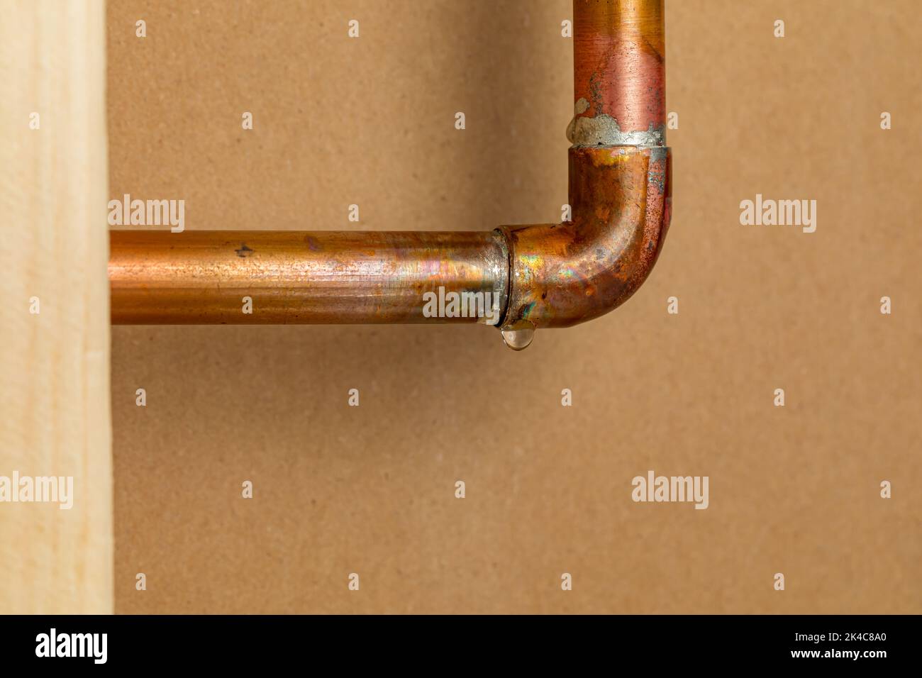 Copper plumbing pipe leaking water inside wall. Home repair, maintenance and remodeling concept. Stock Photo