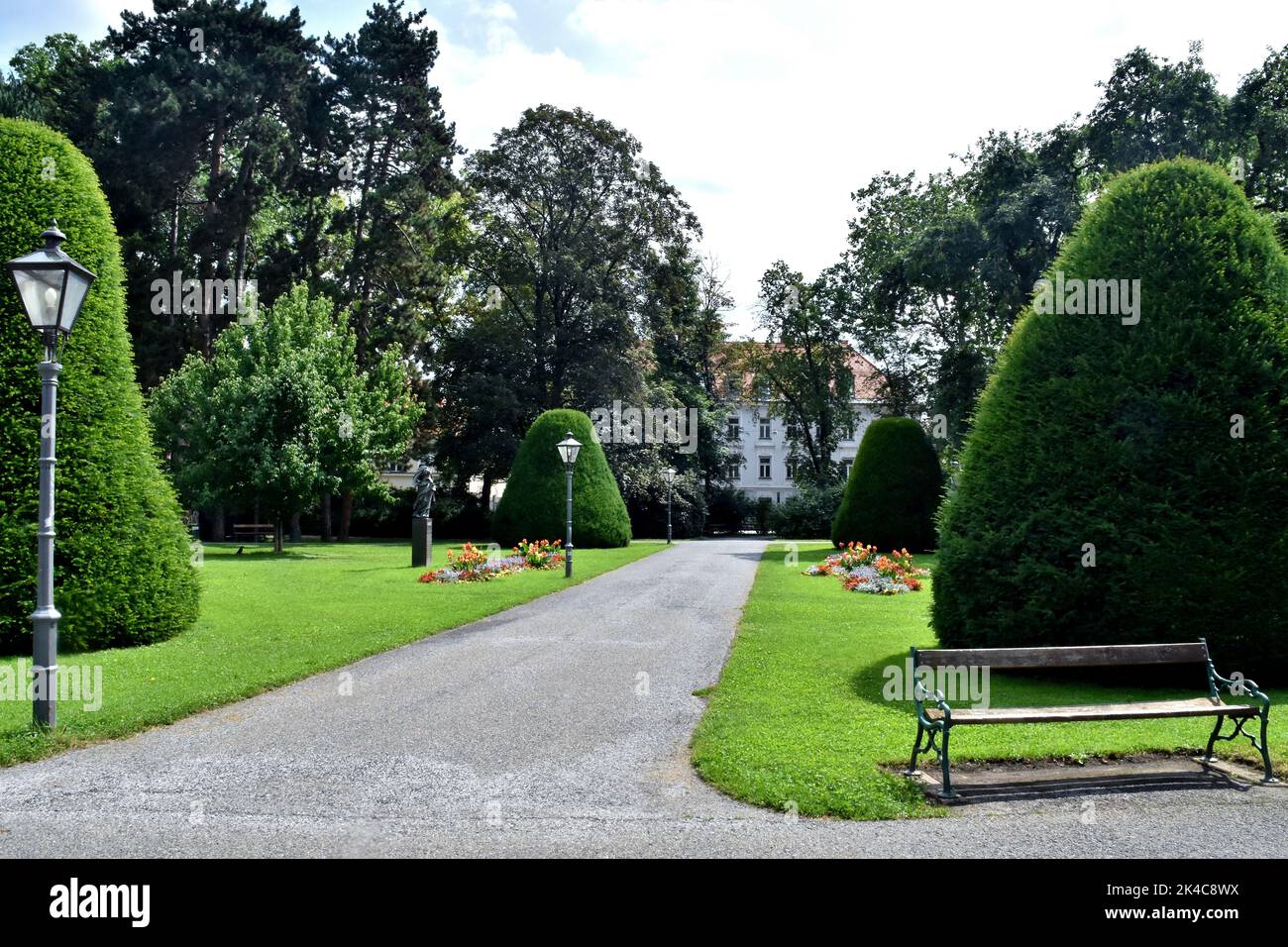 The view of decorated plants in a park before a building on a sunny day Stock Photo