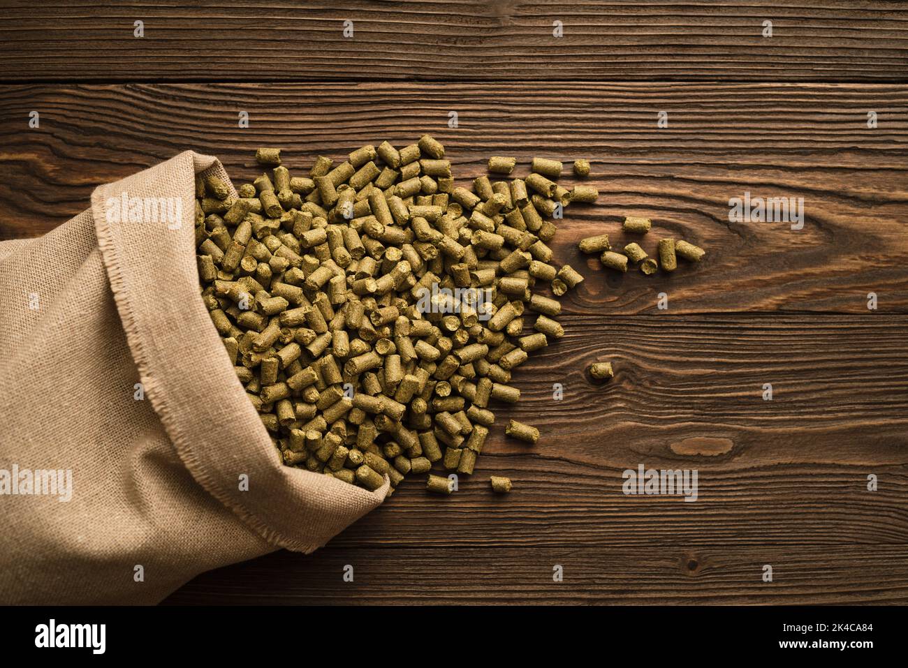 Granules of brewing hops in a bag on a wooden background Stock Photo